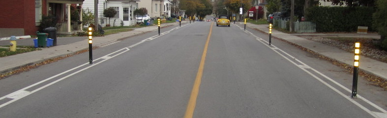 Reflective bollards on Prospect Street used as a barrier between car lanes and bike lanes.